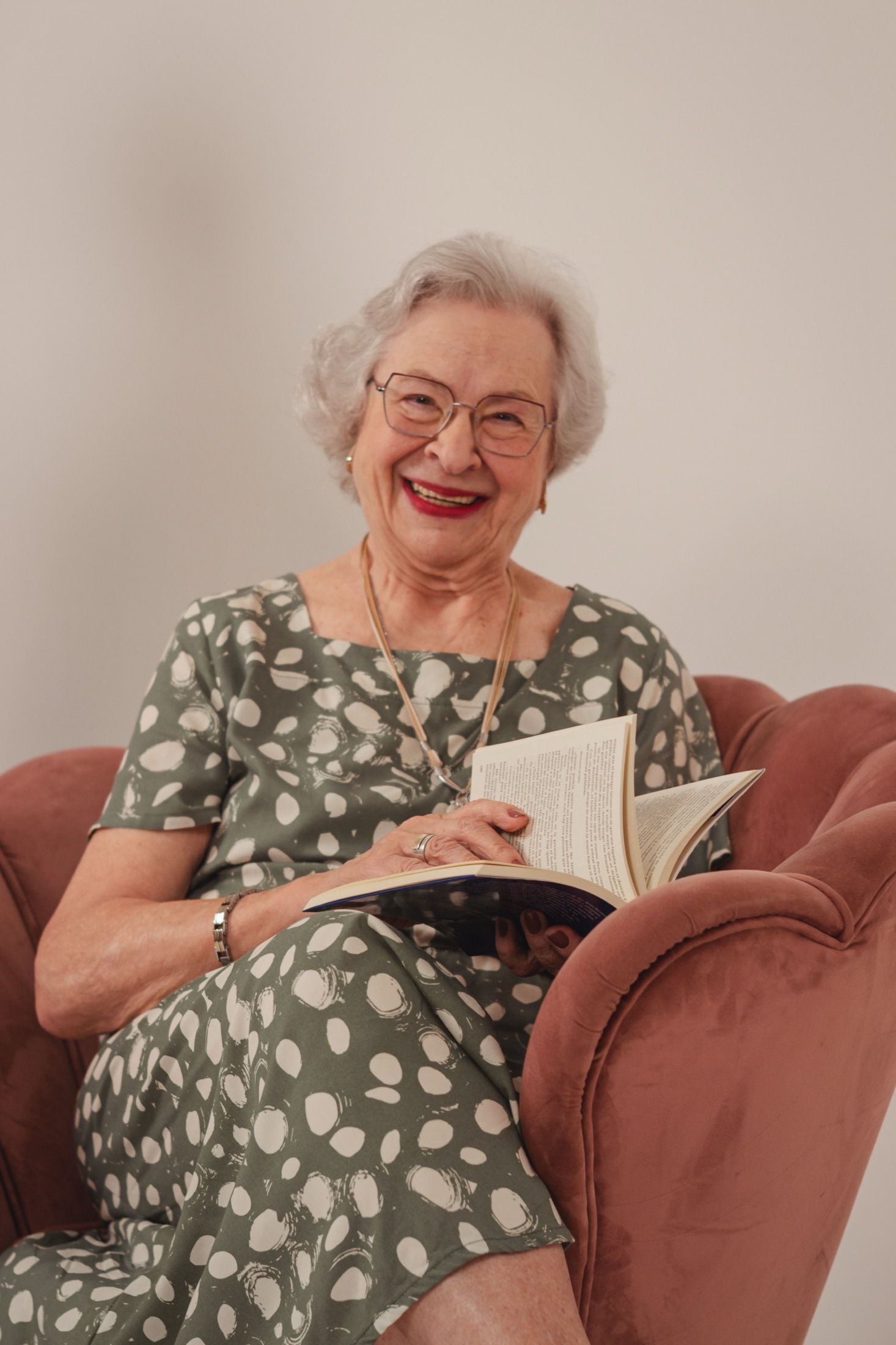 A resident laughing while reading in an armchair