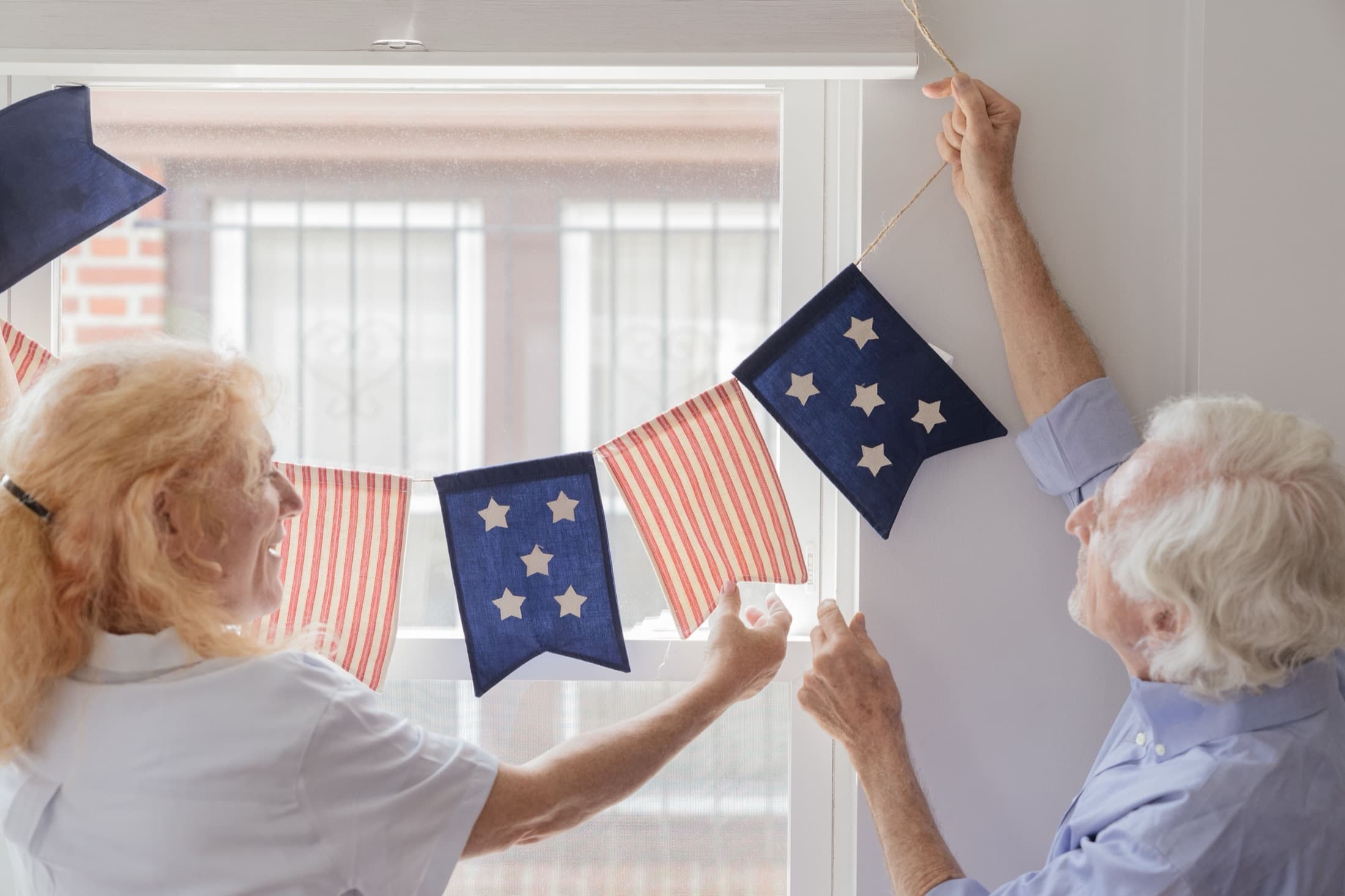 Two residents laughing together while hanging decorations