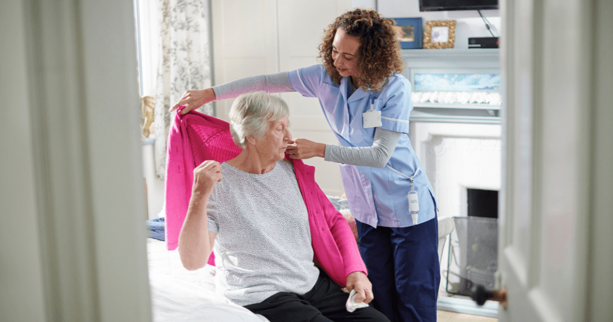 A member of staff helping a resident get dressed