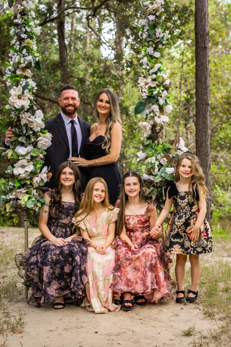 Russell and Brittany Harris with their daughters, seated on a garden swing